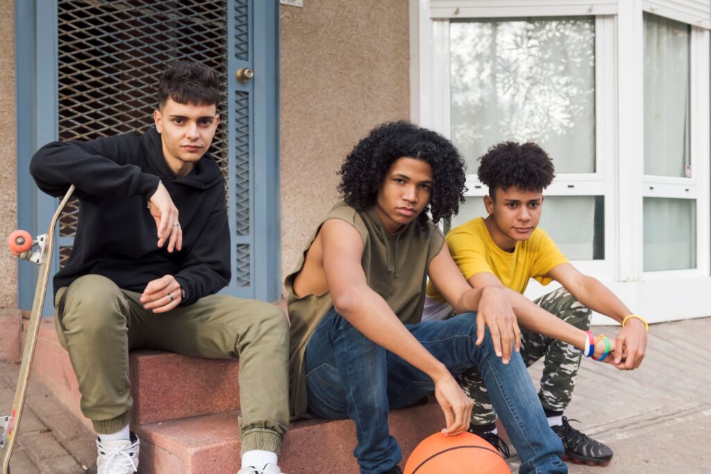 three confident multiracial male teenagers sitting
